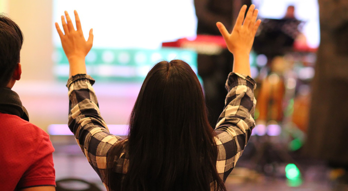 July 2021 young woman hands raised