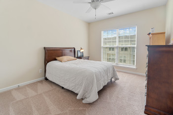Bedroom with light colored carpet and ceiling fan