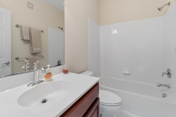 Full bathroom featuring tile floors, oversized vanity, tiled shower / bath combo, and toilet