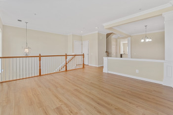 Empty room featuring crown molding, light wood-type flooring, and a chandelier