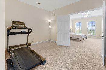 Workout room featuring light colored carpet and ceiling fan