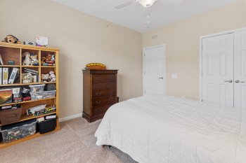 Bedroom featuring a closet, light carpet, and ceiling fan