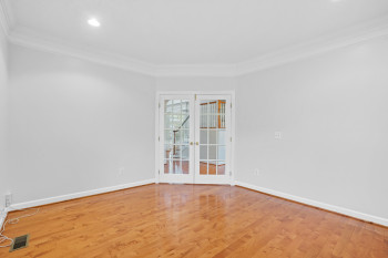 Spare room featuring french doors, ornamental molding, and light hardwood / wood-style flooring