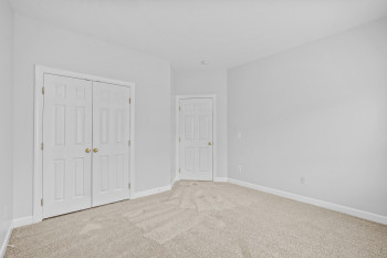 Unfurnished bedroom with light colored carpet and a closet