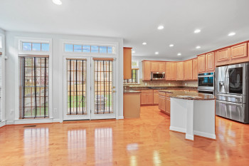 Kitchen featuring plenty of natural light, dark stone counters, light hardwood / wood-style floors, and stainless steel appliances