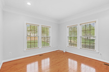 Spare room with crown molding and light hardwood / wood-style floors