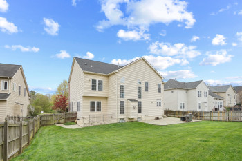 Back of house with a patio and a yard