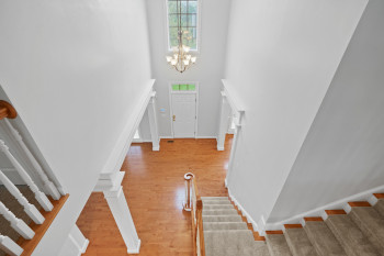 Entrance foyer with an inviting chandelier, light hardwood / wood-style flooring, and a towering ceiling
