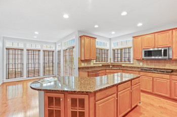 Kitchen featuring a kitchen island, tasteful backsplash, appliances with stainless steel finishes, and light wood-type flooring