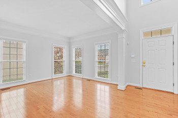 Entrance foyer with ornate columns, a healthy amount of sunlight, and light wood-type flooring