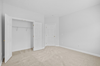 Unfurnished bedroom with a closet and light carpet
