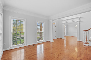 Empty room with a wealth of natural light, light hardwood / wood-style floors, and crown molding