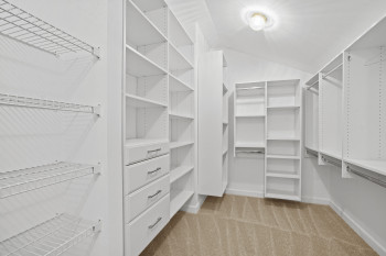 Walk in closet featuring light colored carpet