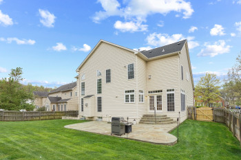Rear view of property with a yard and a patio