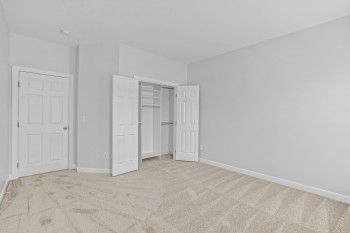 Unfurnished bedroom featuring light carpet and a closet