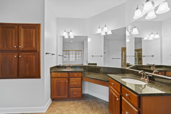 Bathroom featuring an inviting chandelier, tile floors, and double vanity