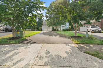 View of front of property featuring a garage and a front lawn