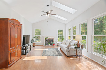 Living room with a wealth of natural light, light hardwood / wood-style flooring, and a skylight