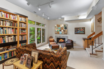Living room with carpet, track lighting, a fireplace, and stairs
