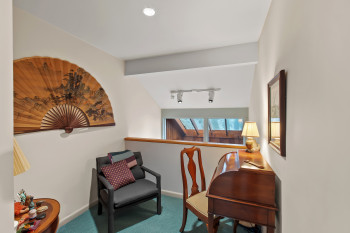 Living area with carpet floors, rail lighting, and lofted ceiling