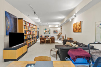 Carpeted living room with rail lighting, a fireplace, and stairway