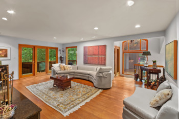 Living room with light wood-style flooring and recessed lighting
