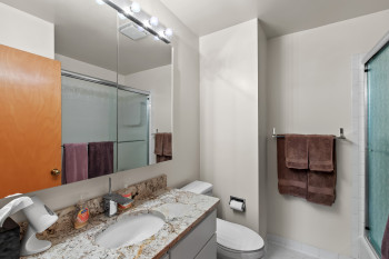 Full bathroom with an enclosed shower, vanity, and tile patterned flooring