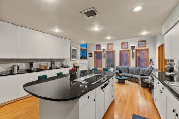 Kitchen with black electric cooktop, a kitchen island, white cabinetry, and recessed lighting