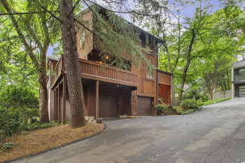 View of front of property featuring asphalt driveway and an attached garage