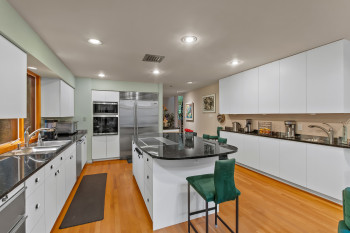 Kitchen featuring stainless steel appliances, a kitchen island, white cabinets, light wood-type flooring, and recessed lighting