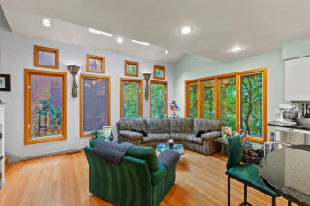 Living room with light wood-type flooring and recessed lighting