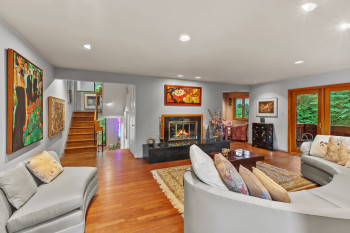 Living area with light wood-style flooring, recessed lighting, stairs, and a fireplace