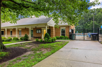 View of front facade with brick siding, covered porch, and a gate