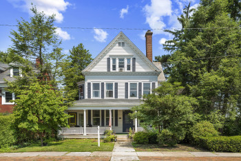 View of front of property with covered porch and a chimney