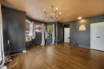Unfurnished room featuring wood finished floors, arched walkways, a chandelier, and cooling unit