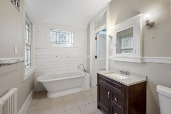 Bathroom featuring a soaking tub, radiator heating unit, vanity, and tile patterned floors