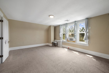 Carpeted spare room with baseboards and cooling unit