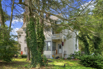 View of front of home with a balcony, entry steps, and a front yard