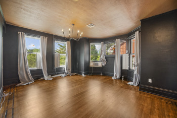 Spare room with wood finished floors, a chandelier, a textured ceiling, and cooling unit