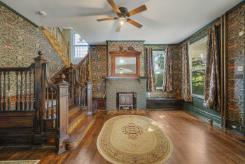 Living room featuring hardwood / wood-style flooring, a ceiling fan, and stairway