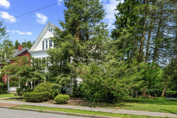 View of property exterior featuring a lawn and a trampoline
