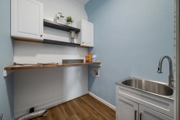 Kitchen with dark wood finished floors, open shelves, white cabinetry, and dark countertops