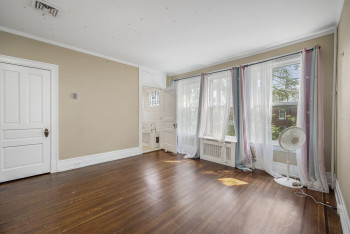 Empty room with ornamental molding and wood finished floors