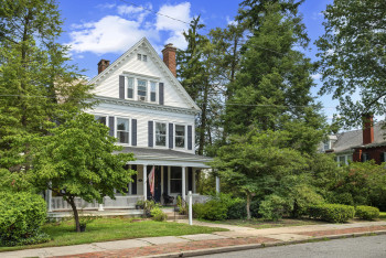 View of front of property with a porch and a chimney