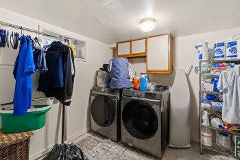 Laundry room with separate washer and dryer and cabinet space
