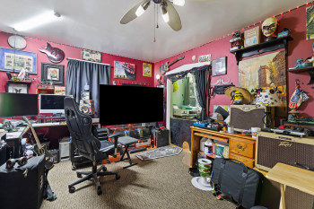 Carpeted office space with ceiling fan