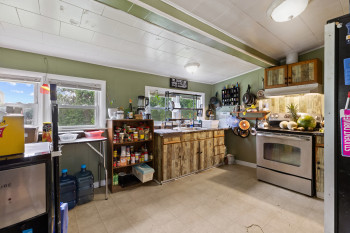 Kitchen featuring stainless steel electric range oven, brown cabinets, freestanding refrigerator, and light floors