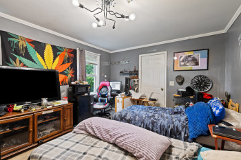 Bedroom with ornamental molding and a chandelier
