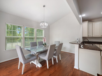 Dining space featuring vaulted ceiling, dark wood finished floors, and a chandelier