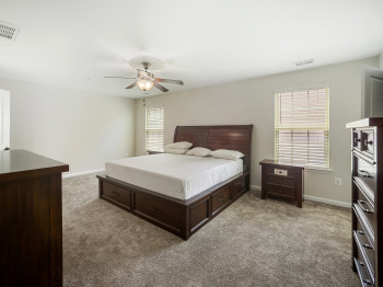 Bedroom with light colored carpet and ceiling fan